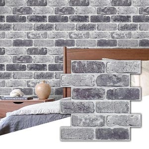 Könnte beinhalten: Graue Ziegel-Peel-and-Stick-Tapete mit strukturierter Oberfläche. Die Tapete ist an einer Wand hinter einem Bett angebracht.