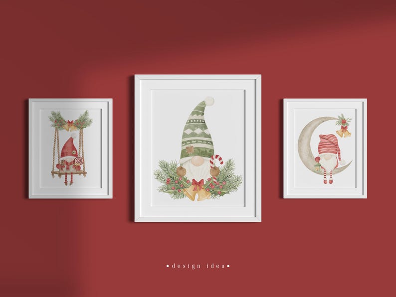 May include: Three white framed prints featuring watercolour illustrations of gnomes. The first gnome is on a swing, the second gnome is holding a candy cane, and the third gnome is sitting on a crescent moon.