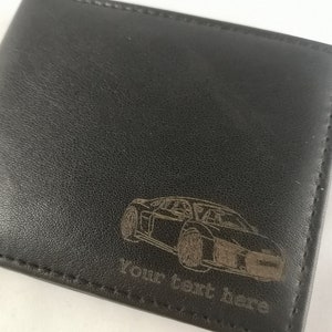May include: Black leather wallet with a laser engraved image of a car and the text "Your text here".