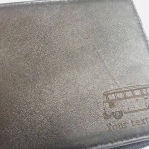 May include: Black leather wallet with an engraved image of a vintage van and the text "Your text here".
