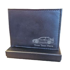 Puede incluir: Cartera de cuero negro con un contorno plateado de un coche y el texto "Your Text Here" grabado en la parte delantera. La cartera está en una caja de regalo negra.