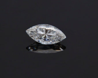 May include: A clear marquise-shaped diamond gemstone on a black background.