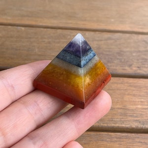 May include: A seven-layered pyramid made of various crystals, including amethyst, clear quartz, lapis lazuli, green aventurine, citrine, carnelian, and red jasper.