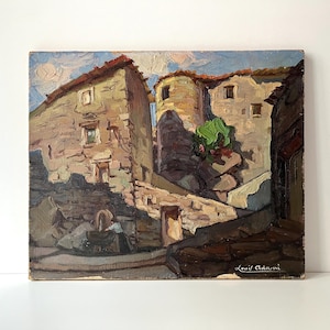 Puede incluir: Pintura al óleo de una escena de pueblo europeo con edificios de piedra, una torre redonda y un arbusto verde. La obra de arte tiene una paleta de colores cálidos con tonos de marrón, beige y azul. Firmado "Louis Adami" en la esquina inferior derecha.