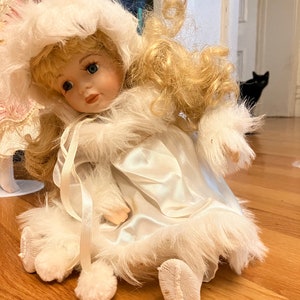 Muñeca de porcelana sentada.