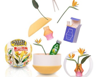 May include: A set of miniature home decor items, including a yellow and white planter, a clear glass bottle with a green label, a small blue vase, and a yellow and white globe with the text "Mini Verse Make it Mini Lifestyle".