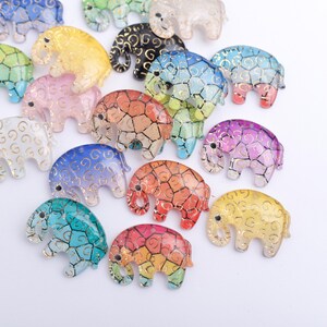 May include: Assortment of colorful glass elephant figurines with gold accents. Each elephant has a different color gradient and intricate patterns.