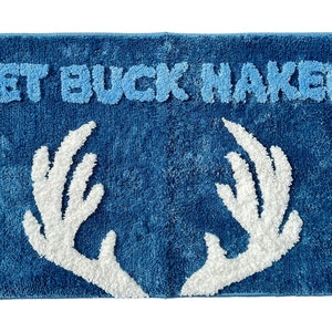 May include: Blue bath mat with white antlers and the text "Get Buck Naked" in white.
