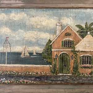 May include: A painting of a small, brown house with a green door and windows. The house is situated on a hill overlooking the ocean, with two sailboats in the distance. The sky is blue with white clouds. There are pink flowers in the foreground.