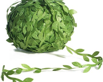 Puede incluir: Un rollo de guirnalda de hojas verdes artificiales con una hebra que se arrastra. Las hojas son de un color verde vibrante y parecen estar hechas de tela. La guirnalda se utiliza probablemente con fines decorativos, como para manualidades o eventos.
