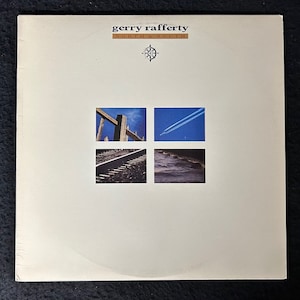 May include: A white vinyl record album cover with the title "Gerry Rafferty North & South" in black text. The cover features four images: a wooden fence, railway tracks, a blue sky with contrails, and a body of water.