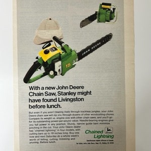 Może przedstawiać: Zielono-żółta piła łańcuchowa John Deere z prowadnicą o długości 38 cm. Piła łańcuchowa znajduje się na białym tle z brązowym kapeluszem w lewym górnym rogu. Tekst "Chained Lightning" znajduje się w prawym dolnym rogu.