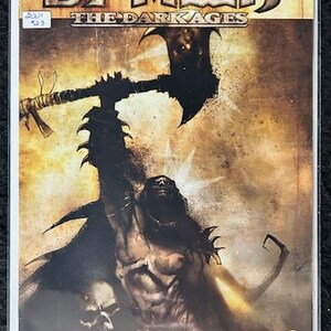 May include: A comic book cover featuring Spawn, a dark, muscular figure with a large axe, against a brown and gold background. The title "Spawn The Dark Ages" is displayed in bold, black letters. The issue number "23" is in the bottom right corner.