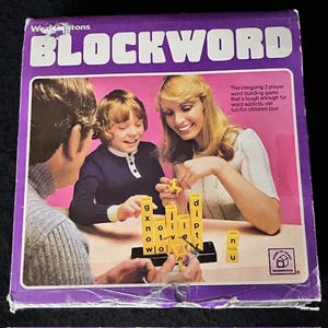 May include: A vintage "BLOCKWORD" board game box with a purple border. The box features a family playing the game, with yellow letter blocks. The text on the box reads "BLOCKWORD" and "Wedvingtons".