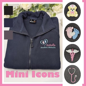 May include: A navy blue zip-up fleece jacket featuring an embroidered logo with a heart, baby footprints, the name Isabelle, and the text Student Midwife. Four circular insets show embroidered icons: a teddy bear, footprints, a caduceus, and a stethoscope.