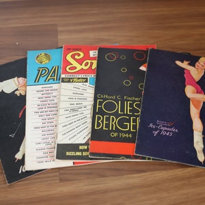 May include: Four vintage sheet music covers with a variety of colors and designs. The covers feature titles like "Paris" and "Folies Berger" and include images of a woman in a skating costume and a musical note.