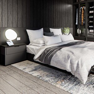 Interior view of a studio cabin featuring a cozy chimney, closet, vanity area, and stylish low-profile bed. Light gray flooring contrasts with dark wood walls. Skylights invite natural light, creating a warm, modern cabin aesthetic.