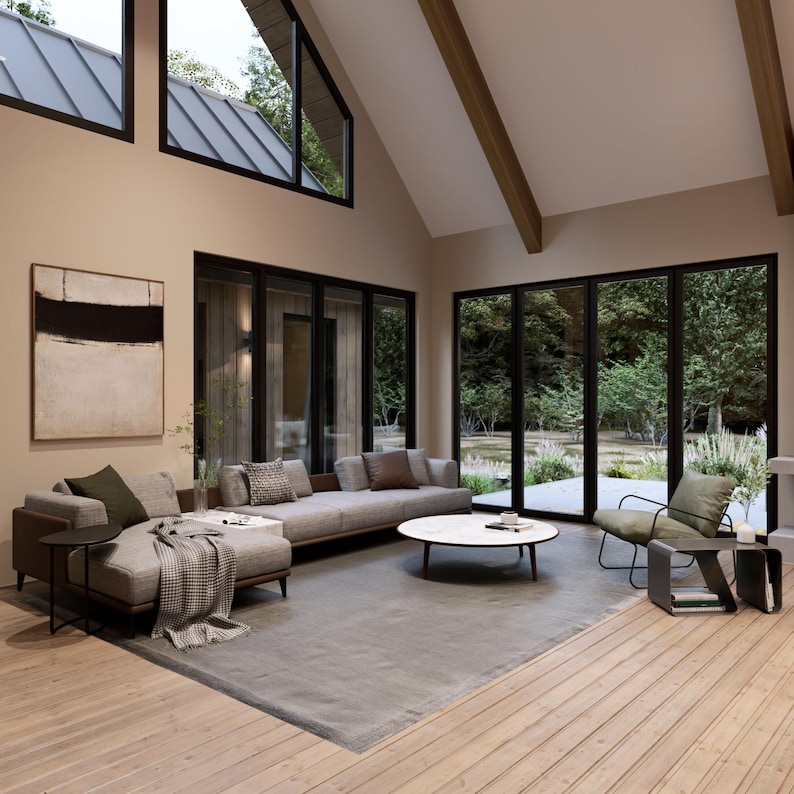 A warm, open-concept living and dining area with vaulted ceilings, exposed wooden elements and floor-to-ceiling windows. A statement fireplace anchors the space, complemented by cozy seating, a sleek dining table, and soft ambient lighting