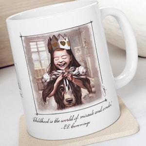 May include: White ceramic mug with a colorful illustration of a girl wearing a crown and holding a dog. The quote "Childhood is the world of miracle and wonder." - E.E. Cummings is printed on the mug.