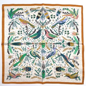 May include: Square silk scarf with a nature-inspired design. The scarf features colourful birds, insects, and foliage in shades of green, pink, yellow, and blue on an off-white background. The border is a solid brown.