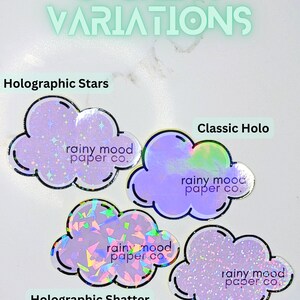 May include: Four cloud-shaped stickers with different holographic finishes. Each sticker features the text "rainy mood paper co."