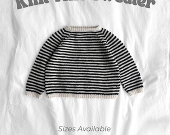 May include: A black and white striped sweater with the text "Knit This Sweater". The sweater is shown on a white background and is available in sizes 3mo, 6mo, 1-2 yrs, 2-3 yrs, and 3-4 yrs.