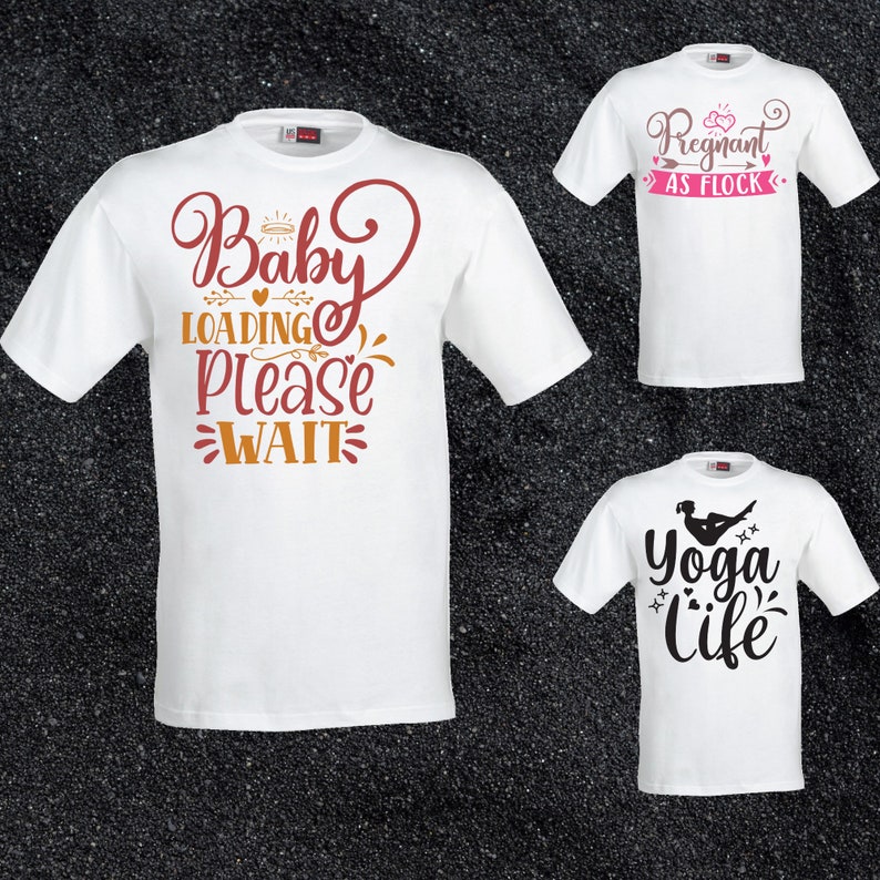 May include: Three white t-shirts with different designs. The first shirt has the text "Baby Loading Please Wait" in brown and orange. The second shirt has the text "Pregnant as Flock" in pink and brown. The third shirt has the text "Yoga Life" in black with a silhouette of a person doing yoga.