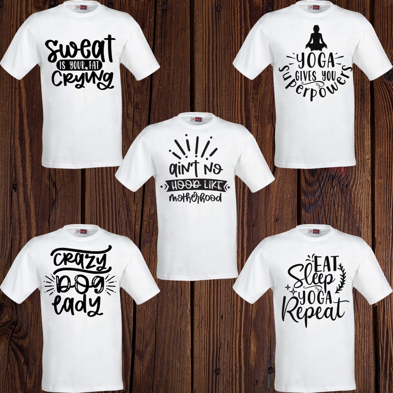 May include: Five white t-shirts with black text and graphics. The shirts feature sayings like "Sweat is your fat crying", "Ain't no hood like motherhood", "Crazy dog lady", "Yoga gives you superpowers", and "Eat sleep yoga repeat".