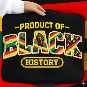 Pode incluir: Capa preta para laptop com o texto "PRODUCT OF BLACK HISTORY" em amarelo. A palavra "BLACK" está em um design colorido com um punho gráfico. A capa é segurada por uma pessoa.