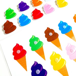 Può includere: Una collezione di adesivi a forma di cono gelato e vortici colorati. I coni gelato hanno basi a cono a cialda e palline colorate rosse, verdi, viola, gialle, marroni, blu e rosa. Gli adesivi a vortice sono di vari colori.