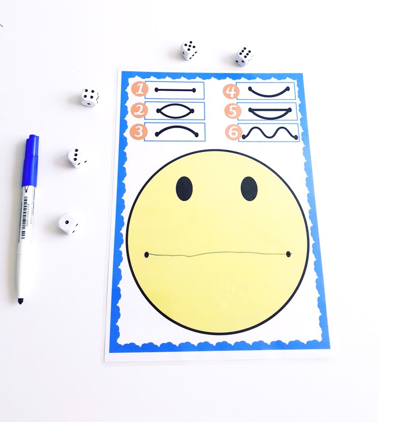 May include: A yellow smiley face game with a blue border, featuring numbered line variations. A blue marker and several dice are scattered around the game board. The game is designed for educational purposes.