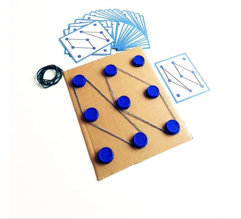 May include: A handmade educational game featuring a cardboard base with blue bottle caps and rubber bands. Includes a set of blue-bordered cards with dot patterns. A green rubber band is also included.