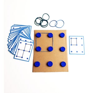 May include: A set of educational materials for a dot-to-dot game. Includes a stack of blue-bordered cards with dot patterns, a cardboard base with blue bottle caps, and rubber bands. The game is designed to teach spatial reasoning and problem-solving skills.