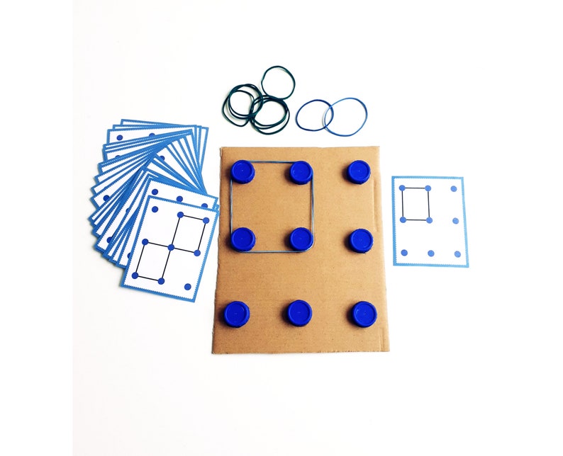 May include: A set of educational materials for a dot-to-dot game. Includes a stack of blue-bordered cards with dot patterns, a cardboard base with blue bottle caps, and rubber bands. The game is designed to teach spatial reasoning and problem-solving skills.