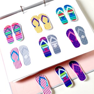 May include: A set of colorful flip-flop shaped paper clips. The clips are in various patterns and colors, including yellow, blue, green, purple, pink, and gray.