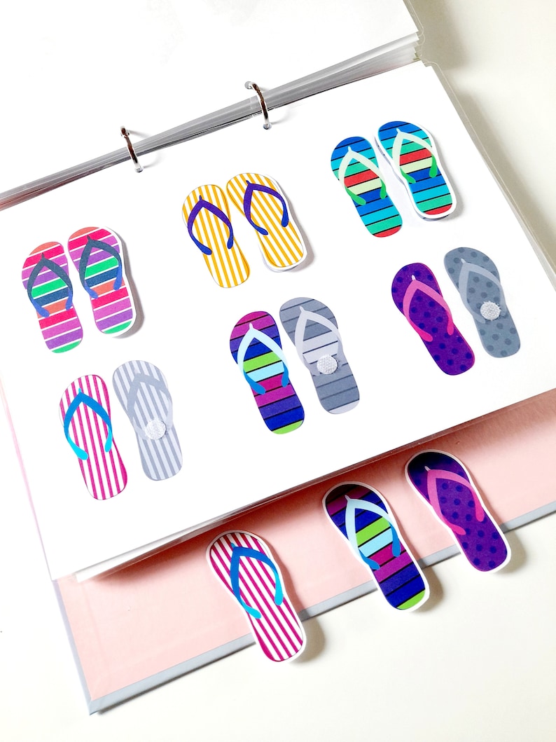 May include: A set of colorful flip-flop shaped paper clips. The clips are in various patterns and colors, including yellow, blue, green, purple, pink, and gray.