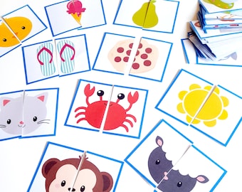 May include: A set of colorful, illustrated puzzle pieces featuring various animals, food, and objects. Each piece is divided in half, with a blue border. The pieces are arranged on a white surface.