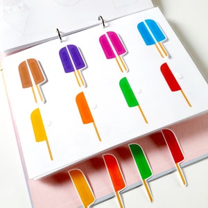 May include: A set of colorful popsicle stickers in various colors, including red, orange, yellow, green, blue, purple, and brown. The stickers are arranged in rows on a white background.