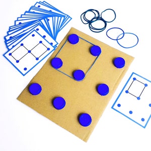 May include: A collection of educational game components, including a cardboard base, blue bottle caps, blue rubber bands, and printed cards with dot patterns. The game is designed for learning and problem-solving, with a focus on visual and spatial reasoning.