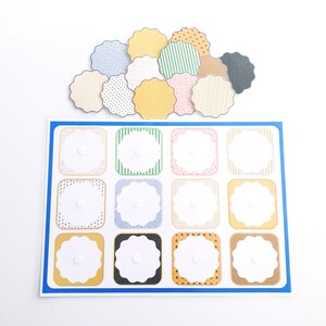 May include: A set of 12 blank, scalloped circle labels with a white center and various patterned borders. The labels are arranged in a grid on a blue background.