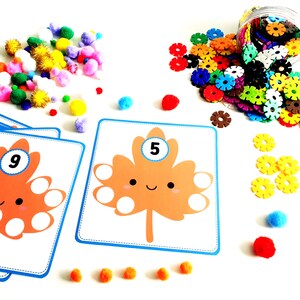 May include: A set of colourful counting cards featuring a cartoon leaf with a smiling face. Each card has a number from 1 to 10 in a circle on the leaf. The cards are designed for children to learn counting and number recognition.