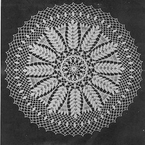 May include: White crochet doily with a delicate floral design. The doily features a central circle with a repeating pattern of leaves and a scalloped edge.