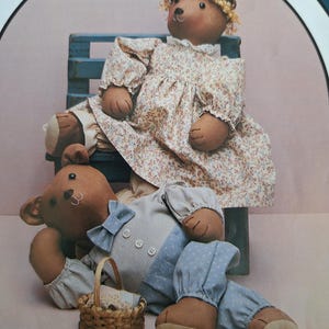 May include: Two brown teddy bears dressed in vintage clothing. The girl bear is wearing a floral dress and sitting on a blue bench. The boy bear is wearing a blue and white checkered shirt, blue pants, and a blue bow tie. He is lying on the floor next to a small wicker basket.