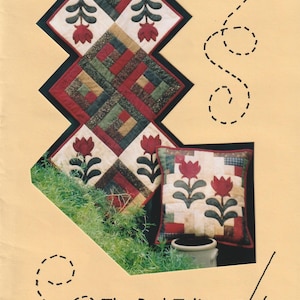 Puede incluir: Un juego de camino de mesa y cojín acolchados con un diseño de tulipán rojo. El camino de mesa mide 51 cm x 104 cm, y el cojín es de 36 cm. El diseño incluye cuadrados rojos, verdes y crema y motivos de tulipanes. El texto dice "The Red Tulip".