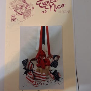 May include: A craft pattern titled "Twice as Nice DESIGNS" featuring patriotic stuffed animal designs. The image shows a red, white, and blue theme with a teddy bear and other figures. The text reads "George Bunnington, Sam & Friend" and "6-inches tall".