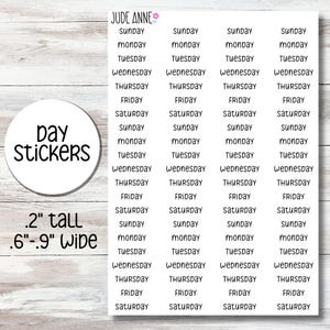 May include: A sheet of white day stickers featuring the text JUDE ANNE with a small flower icon. The stickers are organized in four columns listing the days of the week from Sunday to Saturday. The text indicates the stickers are .2 inches tall and .6 to .9 inches wide.
