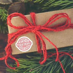 May include: A brown cardboard gift box tied with red twine and a red "Checked 2X Approved Santa Clause" sticker.