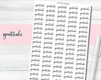 May include: A sheet of white paper with the word "gratitude" written in black cursive script, repeated multiple times.