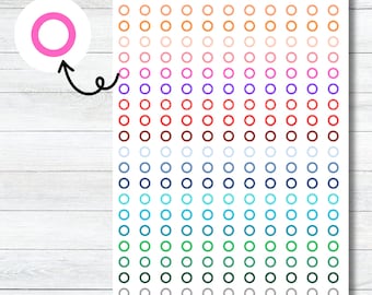 May include: A sheet of colourful circle stickers with a rainbow gradient. The stickers are arranged in rows and columns, with each row featuring a different colour. The colours include yellow, orange, red, pink, purple, blue, green, and black.