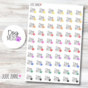 May include: A sheet of stickers with the text "Dog Meds" and paw prints in various colors. A circular sticker with the same text and a purple paw print is also present. The stickers are on a white background.